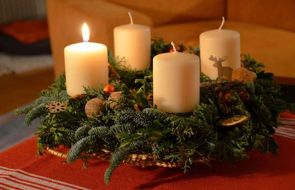 Adventskranz mit einer brennenden Kerze
