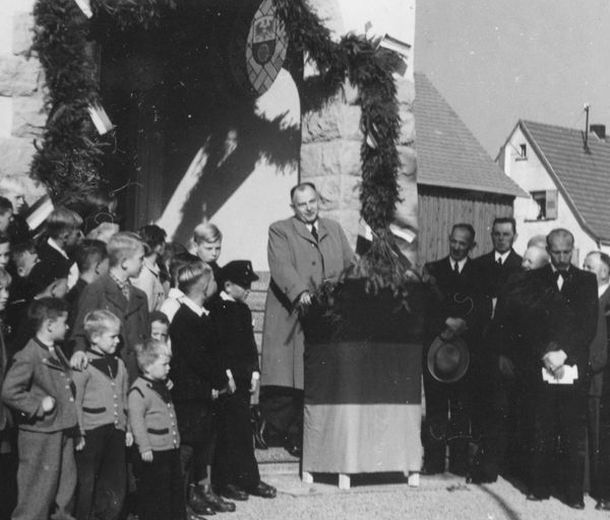 Landrat Kreß bei der Einweihung der Neudorfer Schule, in der ersten Reihe rechts der Lehrer Jeckel
